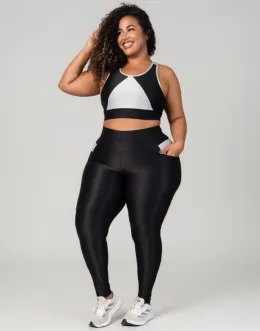 Modelo plus size utilizando conjunto de top e legging bicolor, em preto e branco