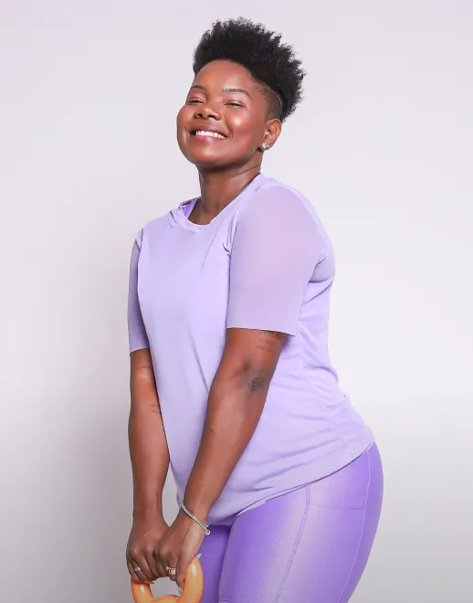 Modelo plus size utilizando um blusão feito em tule, na cor lavanda