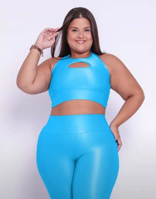 Modelo plus size utilizando o conjunto de legging clássica com top Valquíria, no tecido aveludado de compressão em cor ciano